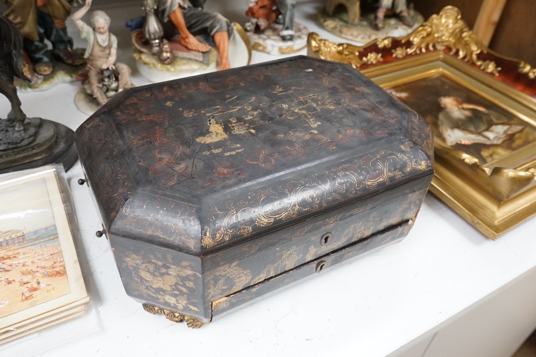 A 19th century Chinese export chinoiserie lacquered work box with paw feet, 36cm wide